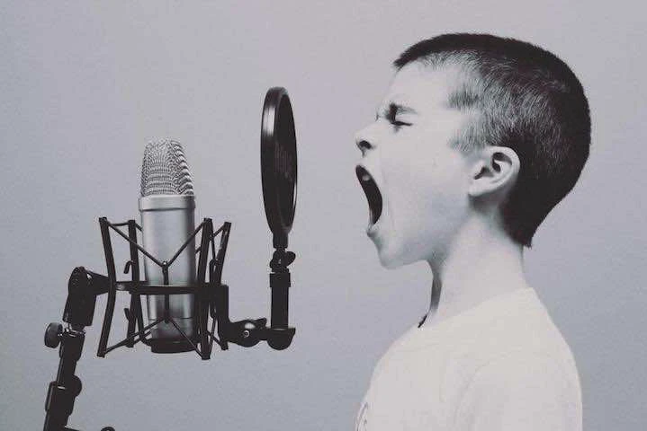 Un enfant chante devant un micro
