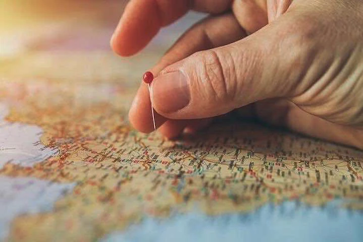 Un homme plante une aiguille sur une carte