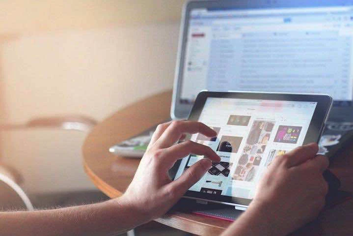 Une personne devant une tablette tactile