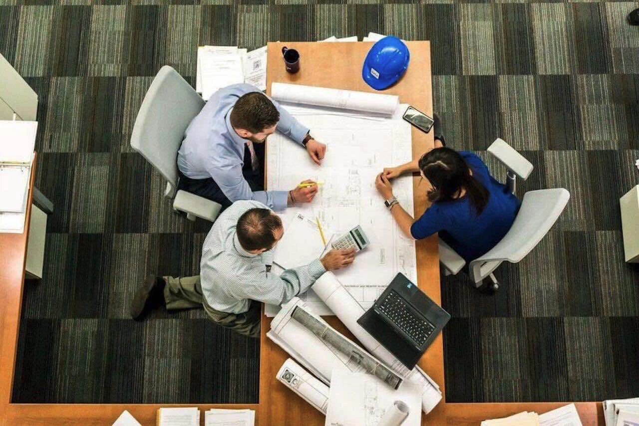 Trois hommes autour d'un bureau