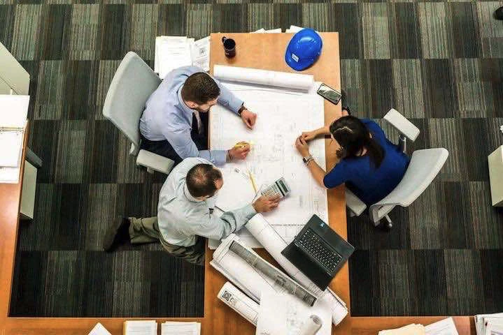 Trois hommes autour d'un bureau