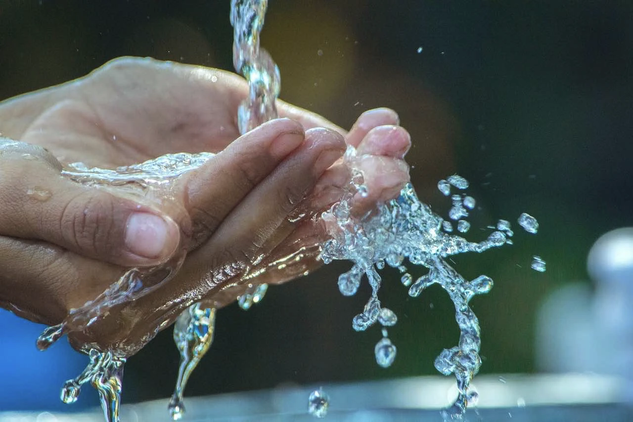 Une source d'eau coule sur des mains