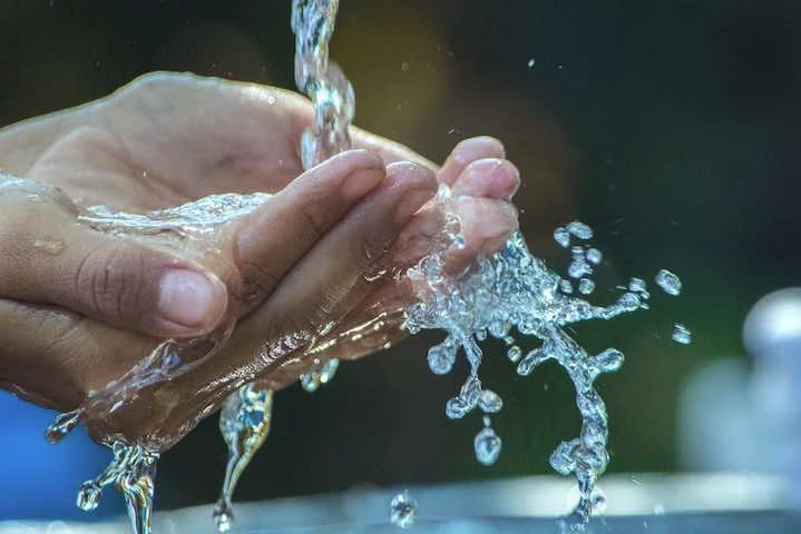 Une source d'eau coule sur des mains